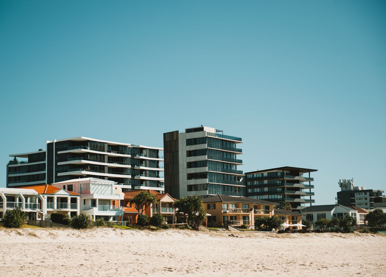 A beachfront view of modern buildings in the Gold Coast, showcasing urban architecture against a clear sky.