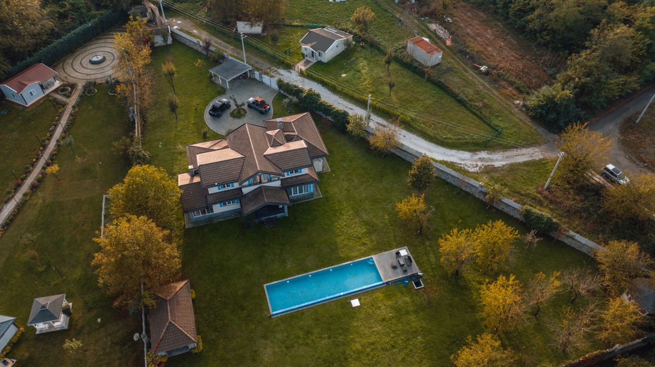 An aerial photograph showcases a beautiful villa with a pool amidst autumnal surroundings in İzmit, Türkiye.