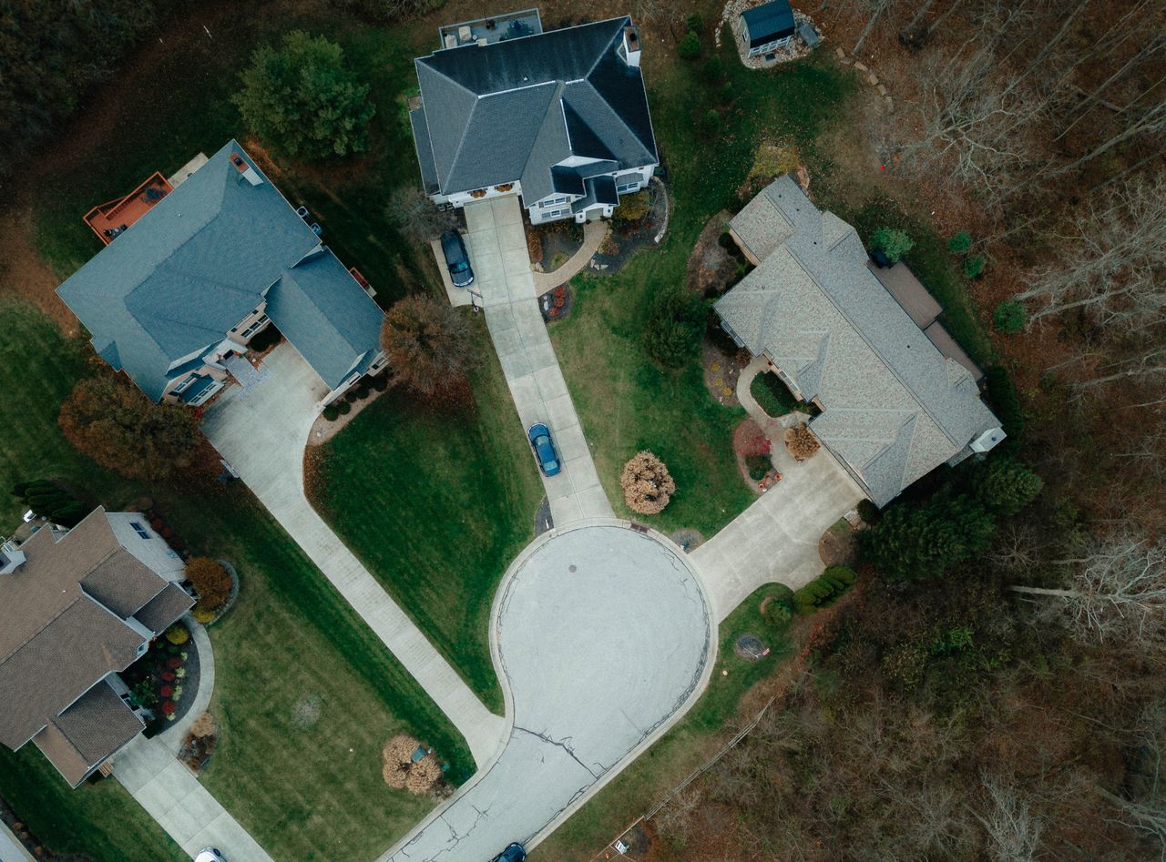 Drone shot of suburban Cincinnati showcasing houses, streets, and greenery from above.