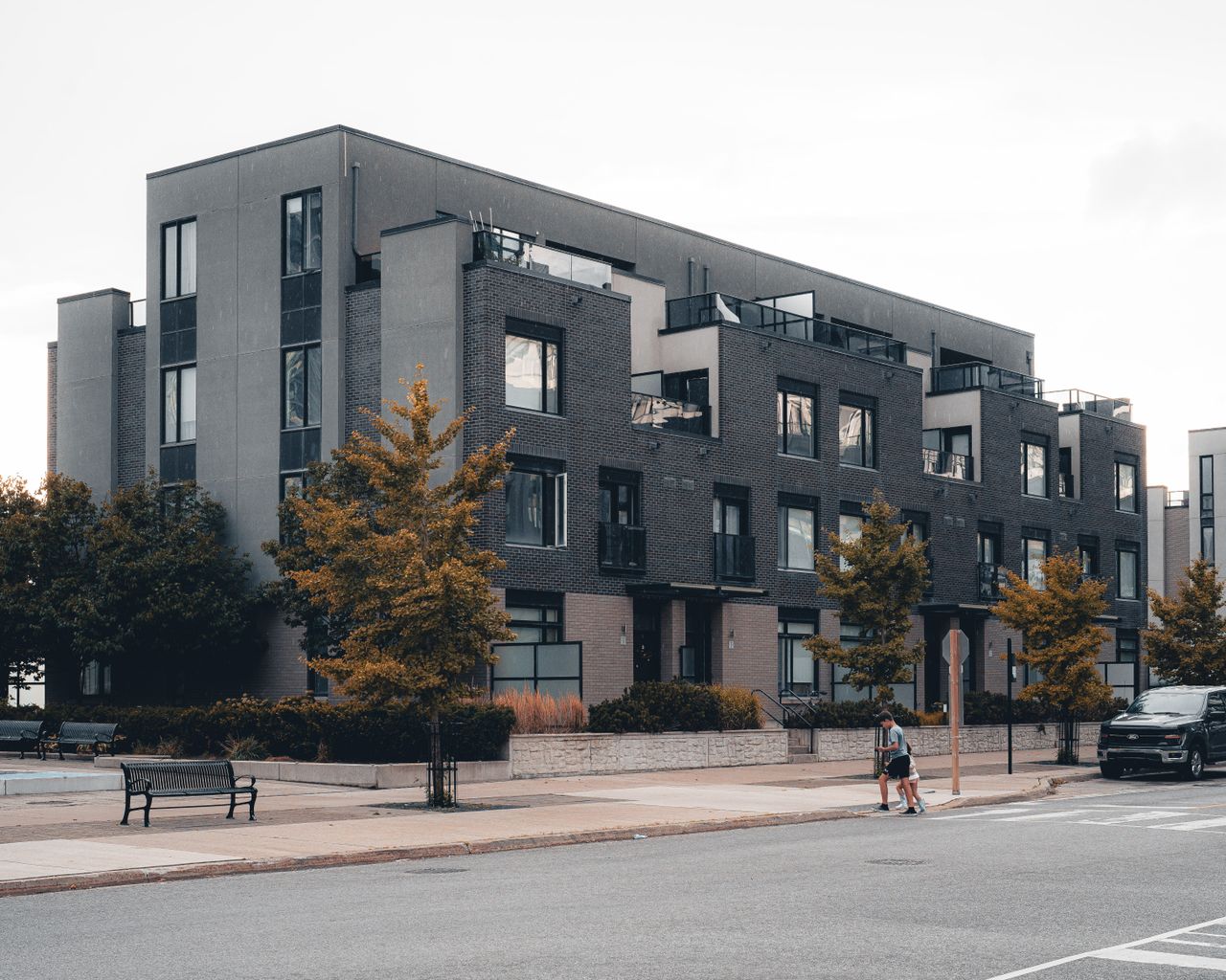 Contemporary urban apartment building with tree-lined street in Mississauga, Ontario.