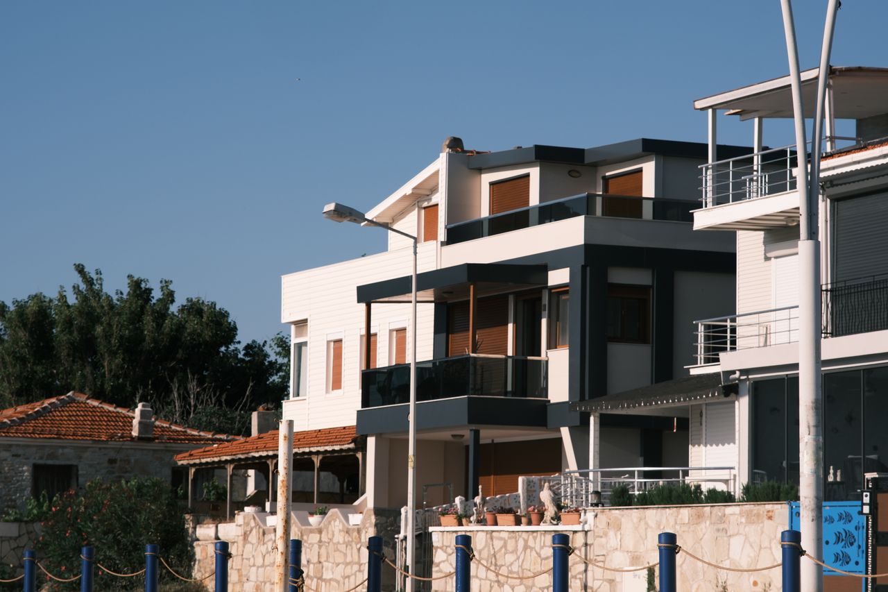 Contemporary and traditional homes in Foça, İzmir, showcasing modern design against a clear sky backdrop.