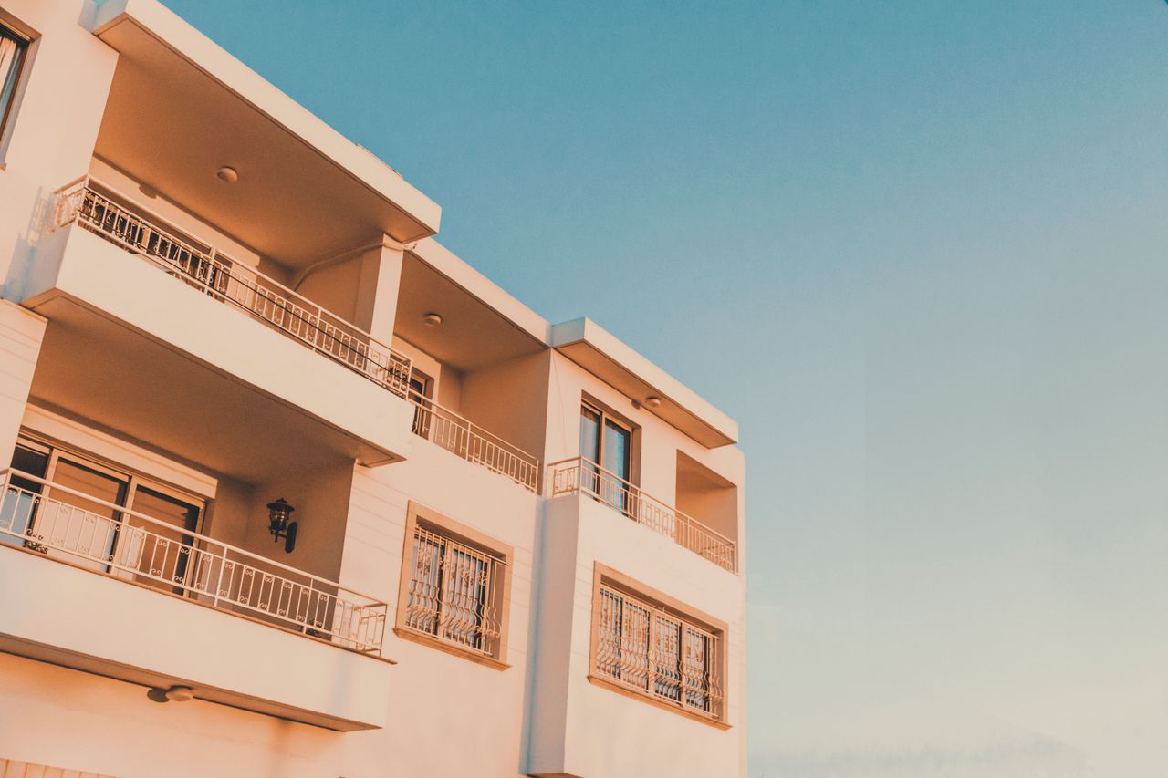 A modern apartment building with balconies in Paphos, Cyprus, captured during a vibrant sunset.